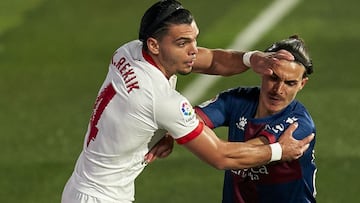 HUESCA, SPAIN - NOVEMBER 28: Jaime Seoane of SD Huesca competes for the ball with Karim Rekik of Sevilla FC during the La Liga Santander match between SD Huesca and Sevilla FC at Estadio El Alcoraz on November 28, 2020 in Huesca, Spain. (Photo by Pedro Sa