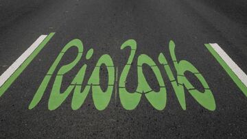 The logo of the Rio 2016 Olympic Games painted in green to distinguish it as the special lane for the games, on a road pedestrianized on Sundays, on June 26, 2016, in Rio de Janeiro, Brazil. / AFP PHOTO / YASUYOSHI CHIBA