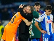 El entrenador del Barcelona Hans-Dieter Flick (c) abraza a Joan García al finalizar el partido de la jornada 18 de LaLiga entre el RCD Espanyol y el FC Barcelona, este sábado en el RCDE Stadium.