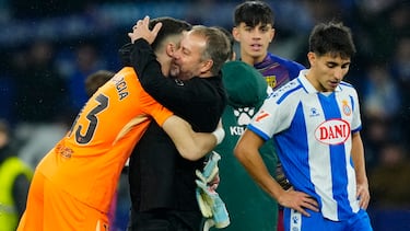 CORNELLÁ-EL PRAT (BARCELONA), 03/01/2026.- El entrenador del Barcelona Hans-Dieter Flick (c) abraza a Joan García al finalizar el partido de la jornada 18 de LaLiga entre el RCD Espanyol y el FC Barcelona, este sábado en el RCDE Stadium. EFE/Alejandro García