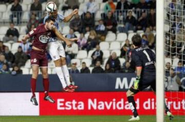 El delantero paraguayo del Málaga Roque Santa Cruz (c) cabecea un balón ante Pablo Insúa, del Deportivo de La Coruña, durante el partido de vuelta de los dieciseisavos de final de la Copa del Rey que disputan esta noche en el estadio de La Rosaleda, en Málaga.