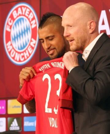 Arturo Vidal posa con su nueva camiseta del Bayern Munich junto al director deportivo del club, Matthias Sammer.