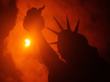La Estatua de la Libertad de Nueva York contempló el fenómeno que tiño de luz naranja y oscuridad el país.