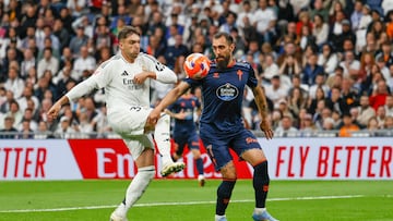 El defensa del Real Madrid Raúl Asencio lucha por el balón con el delantero del Celta de Vigo Borja Iglesias durante el partido entre el Real Madrid y el Celta de Vigo este domingo en el estadio Santiago Bernabéu en Madrid este domingo.