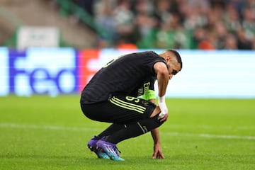 Benzema touches his right knee after feeling pain at Celtic Park.