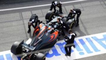 Los mec&aacute;nicos de McLaren empujan el coche de Fernando Alonso hacia el box.