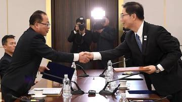 Fotografía cedida por el Ministerio de Unificación de Corea del Sur, muestra a los delegados principales de Corea del Norte y Corea del Sur quienes se dan la mano después de intercambiar un comunicado conjunto al final de las conversaciones olímpicas intercoreanas en la aldea fronteriza de Panmunjom, (Corea del Norte).