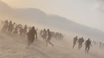 Siluetas de gente corriendo en la playa de Villers-sur-Mer, Baja Normandía, Francia, el 19 de junio del 2022, por un mini tornado.