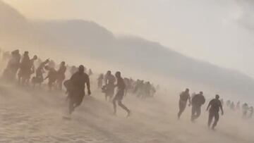 Siluetas de gente corriendo en la playa de Villers-sur-Mer, Baja Normand&iacute;a, Francia, el 19 de junio del 2022, por un mini tornado. 