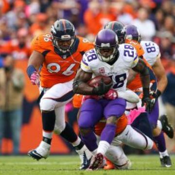 Adrian Peterson perseguido por la defensa de Denver.