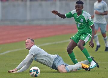 Wayne Rooney falls after a tackle by Gor Mahia's Kennedy Muguna.