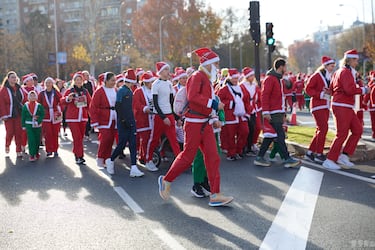 Decenas de personas durante la XIII Carrera de Papá Noel, a 22 de diciembre de 2024, en Madrid (España).