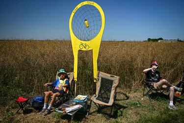 Espectadores se alinean a lo largo del recorrido de la carrera con un objetivo de cartón improvisado para atrapar bidones durante la quinta etapa de la 112.ª edición del Tour de Francia, una contrarreloj individual de 33 km con inicio y fin en Caen.
