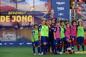 El jugador holandés posando y jugando junto a niños de la cantera del Barça. 