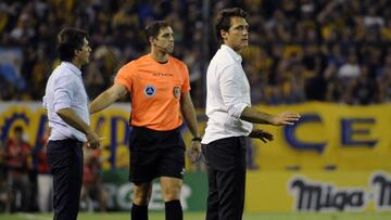Boca Juniors' coach Guillermo Barros Schelotto (R) and his brother and assistant Gustavo gesture during their Argentina's Superliga first division football match against Rosario Central at Gigante de Arroyito stadium in Rosario, Santa Fe, on November 26, 2017. / AFP PHOTO / STRINGER