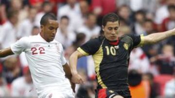 Theo Walcott y Eden Hazard pelean por el bal&oacute;n durante el encuentro entre las selecciones inglesa y belga en Wembley.
