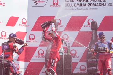 El piloto italiano Enea Bastianini, del equipo Ducati Lenovo, en el centro, celebra en el podio con el piloto español Jorge Martín, del equipo Prima Pramac Racing, en segundo lugar, a la izquierda, y el piloto español Marc Márquez, del equipo Gresini Racing MotoGP, en tercer lugar.