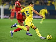 VILLARREAL (CASTELLÓN), 22/02/2026.- El defensa uruguayo del Villarreal Santiago Mouriño (d) intenta llevarse el balón ante el delantero nigeriano del Valencia Umar Sadiq durante el encuentro correspondiente a la jornada 25 de Laliga EA Sports que disputan Villarreal CF y Valencia CF este domingo en el estadio de La Cerámica de Villarreal. EFE/ Andreu Esteban