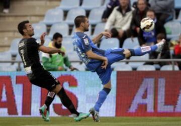El defensa del Getafe Álvaro Arroyo intenta despejar junto a David Barral, del Levante