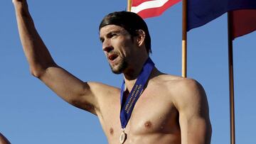 Repóquer olímpico. Michael Phelps celebrando sus quintos Juegos junto a la bandera de su país.