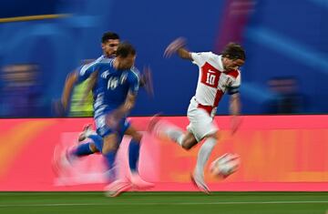 El centrocampista croata Luka Modric corre con el balón ante el jugador italiano Nicolo Barella durante el último partido del Grupo B.