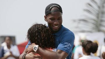 CTG03. CARTAGENA (COLOMBIA), 18/03/2018.- El futbolista marfile&ntilde;o Didier Drogba (d) abraza a una ni&ntilde;a durante una pr&aacute;ctica de f&uacute;tbol que condujo con un grupo de j&oacute;venes de las fundaciones Amigos del Mar y F&uacute;tbol c