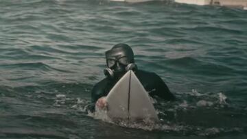 Un surfista con m&aacute;scara para evitar la contaminaci&oacute;n en la zona de Quintero-Puchuncav&iacute; (Chile), entre centrales carboneras. 