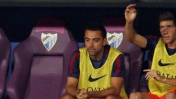 Xavi, con el gesto ausente, en el banquillo de La Rosaleda, al lado de Sergi Roberto, que a&uacute;n ha jugado menos en Liga.
 