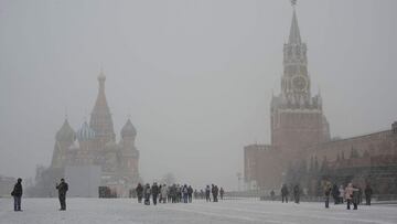 People visit Red Square during a snowfall in central Moscow on March 28, 2022. (Photo by Natalia KOLESNIKOVA / AFP)