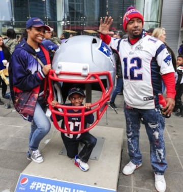 Varios aficionados posan en el casco del los New England Patriots delante del George R. Brown Convention Center de Houston.