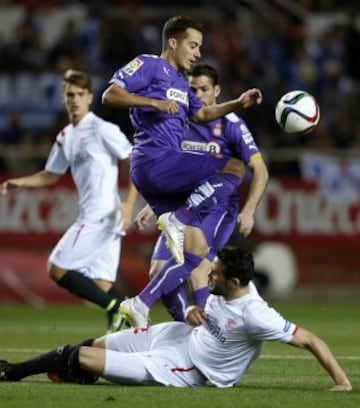 Lucas Vázquez salta ante la entrada del jugador del Sevilla Vicente Iborra.