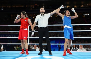 Nien Chin Chen of Taiwan reacts as Match Referee Jakov Peterson raises the hand of Liu Yang of China.