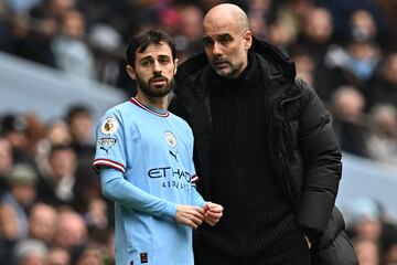 Bernardo Silva y Pep Guardiola, jugador y entrenador del Manchester City, conversan durante un partido.