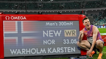 Karsten Warholm posa con el electrónico que refleja su récord del mundo de 300 metros vallas.