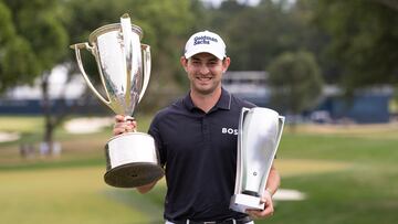 El golfista australiano Patrick Cantlay posa con los trofeos de campeón del BMW Championship en el Wilmington Country Club.