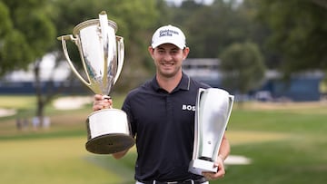 El golfista australiano Patrick Cantlay posa con los trofeos de campeón del BMW Championship en el Wilmington Country Club.