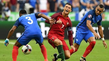 France's forward Dimitri Payet (R) looks on as Portugal's forward Cristiano Ronaldo falls onto the pitch during the Euro 2016 final