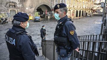 CATANIA, ITALY - MARCH 12: Police with the protective masks control the traditional open-air fish market "a piscaria" closed due to the Coronavirus emergency on March 12, 2020 in Catania, Italy. The Coronavirus pandemic closes the Italian territory for the third day. The new provisions of the prime minister Giuseppe Conte against the spread of Covid-19 require the closure of all commercial activities except supermarkets, pharmacies, tobacconists, newsagents and banks. Factories and transports remain open. (Photo by Fabrizio Villa/Getty Images)