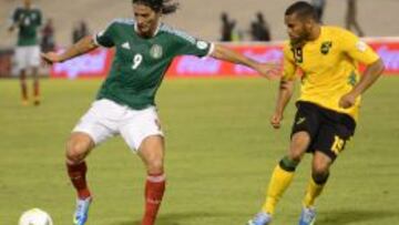 El jugador de México Aldo de Nigris disputa un balón con el jamaicano Adrain Mariappa.