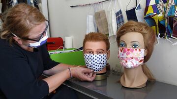 Una modista coloca una mascarilla de diseño a un maniquí.