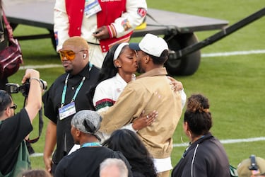 La actriz Coco Jones y el jugador de los Cleveland Cavaliers Donovan Mitchell se besan antes del partido.