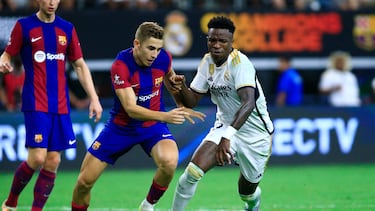 Real Madrid's Brazilian forward Vini Jr. (R) vies for the ball with Barcelona' Spanish forward Fermin Lopez during a pre-season friendly football match between FC Barcelona and Real Madrid CF at AT&T Stadium in Arlington, Texas on July 29, 2023. (Photo by Aric Becker / AFP)