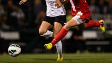 Abby Wambach, de rojo, pelea un bal&oacute;n con Kat Williamson.