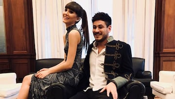 Aitana Ocaña y Luis Cepeda posando sonrientes sentados en un sillón.