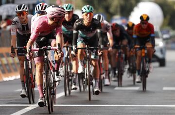 El corredor portugués del equipo Deceuninck, Joao Almeida, vestido con la camiseta rosa de líder, mira hacia atrás mientras cruza la línea de meta en la décima etapa de la carrera