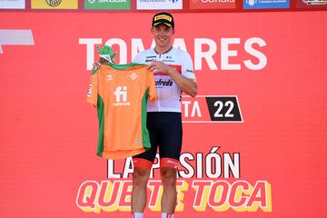 Mads Pedersen celebrando su victoria en el podio como ganador de la etapa (sosteniendo una camiseta del Real Betis Balompi¨¦ - club de f¨²tbol)