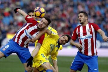  El centrocampista del Atlético de Madrid, Koke Resurección, mira como su compañero, el centrocampista Saúl Ñíguez, disputa un balón con el defensa portugués de Las Palmas Hélder Lopes