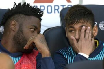 Los jugadores del Barcelona, el brasileño Neymar da Silva (d) y el camerunés Alexandre Song en el banquillo.