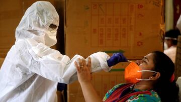 FILE PHOTO: A health worker in personal protective equipment (PPE) collects a swab sample from a woman during a rapid antigen testing campaign for the coronavirus disease (COVID-19) in Mumbai, India, September 7, 2020. REUTERS/Francis Mascarenhas/File Pho