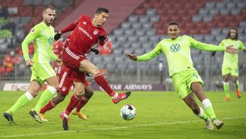 Bayern's Robert Lewandowski, center, challenges for the ball with Wolfsburg's Marin Pongracic, left, and Maxence Lacroix during the German Bundesliga soccer match between FC Bayern Munich and VfL Wolfsburg at the Allianz Arena in Munich, Germany